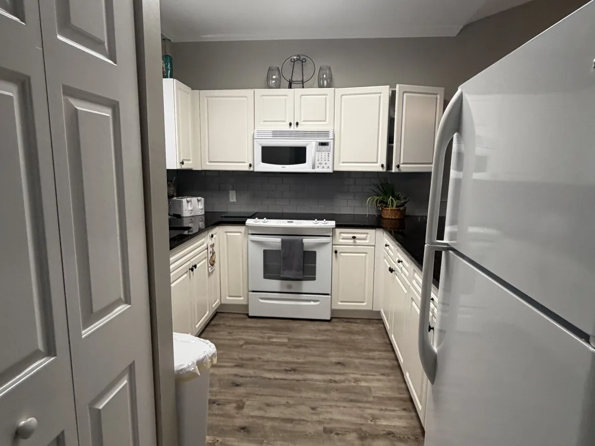 A white range and refrigerator and a wiped countertop