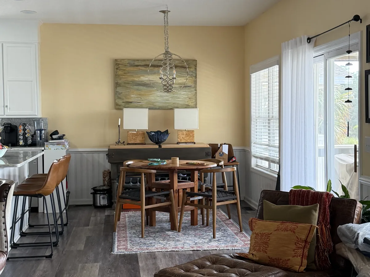 Recently cleaned dining area with a breakfast bar, stools and swept dark wood floor